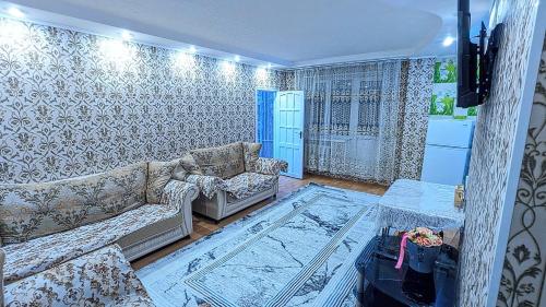 een woonkamer met een bank en een tafel bij Apartments in the center in Taraz