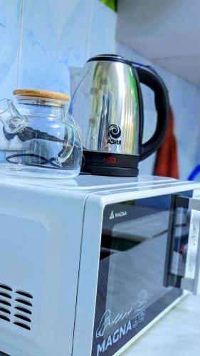 a toaster sitting on top of a microwave at Apartments in the center in Taraz