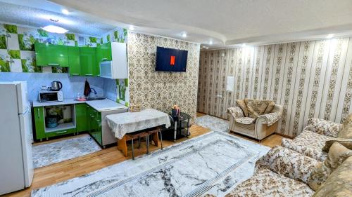 een woonkamer met een bank en een keuken bij Apartments in the center in Taraz