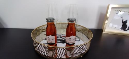 two bottles of beer in a bowl on a table at A Casa da Nocas- Quarto Yellow in Setúbal