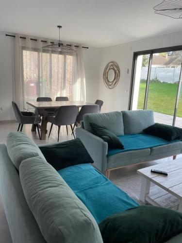 un salon avec un canapé et une table dans l'établissement Maison Bijou 3 chambres à 10min de DisneyLand Paris, à Chalifert