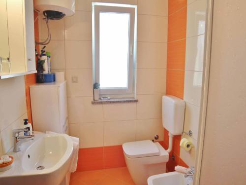 a bathroom with a sink and a toilet and a window at Apartment Gaga in Rovinj