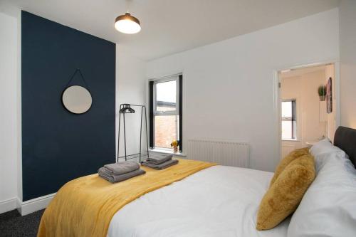 1 dormitorio con 1 cama grande y pared azul en *Cosy home with parking for you* en Derby