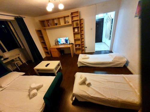 une petite chambre avec deux lits et une table dans l'établissement Ultracentral Apartment - "Saint Anthony" Church & Old Town View, à Bucarest