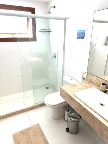 a bathroom with a shower and a toilet and a sink at Villa Ferradura Mar in Búzios