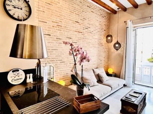 a living room with a couch and a clock on the wall at innCádizPalacio Conde Casa-Brunet in Cádiz
