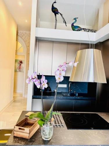 a kitchen with a vase with flowers on a counter at innCádizPalacio Conde Casa-Brunet in Cádiz