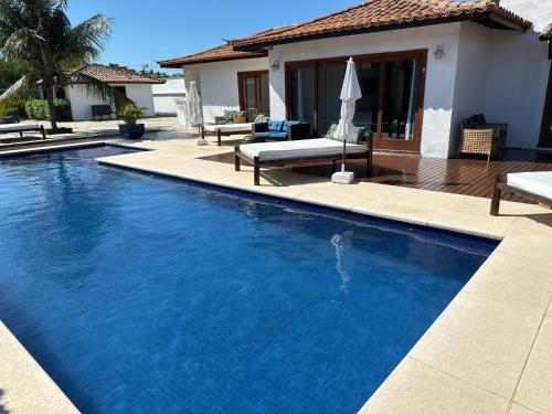 a large blue swimming pool in front of a house at Villa Ferradura Mar in Búzios
