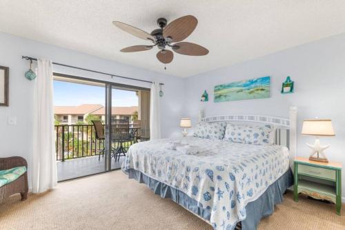 a bedroom with a bed with a ceiling fan and a balcony at Cozy Casita Beach Escape 850 A1A Unit 90 in Saint Augustine