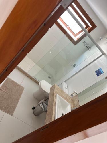 a bathroom with a toilet and a mirror at Villa Ferradura Mar in Búzios