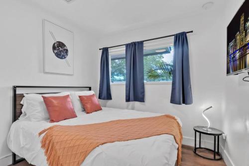 sypialnia z łóżkiem z niebieskimi zasłonami i oknem w obiekcie Escape to Private Poolside Bliss w mieście Hollywood