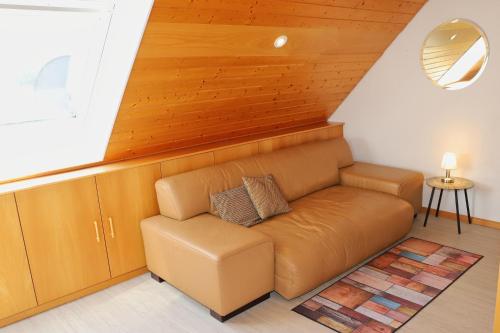 a brown couch in a room with a wooden ceiling at Gästehaus Willaringen in Rickenbach