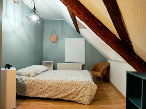 a bedroom with a bed and a clock on the wall at Lancre / Maison kids-friendly en Alsace in Lutzelhouse