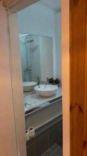 La salle de bains est pourvue de 2 lavabos et d'un miroir. dans l'établissement Brandão House, à Caparica