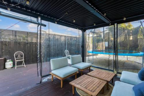 a screened in porch with two chairs and a table at 5-Bedroom Gem - Parking - Sandringham-Mount Eden in Auckland