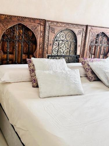 a white bed with pillows on top of it at innCádizPalacio Conde Casa-Brunet in Cádiz