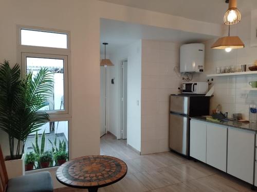 Lovely one bedroom apartment in Vicente Lopez في فيسنتي لوبيز: مطبخ مع ثلاجة وطاولة في الغرفة