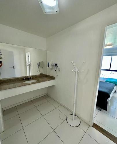 a white bathroom with a sink and a mirror at MANDAI APART in Cabo Frio