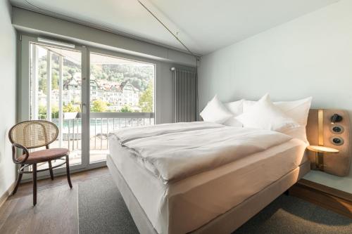 ein Schlafzimmer mit einem großen Bett und einem großen Fenster in der Unterkunft Hotel Aare Thun in Thun
