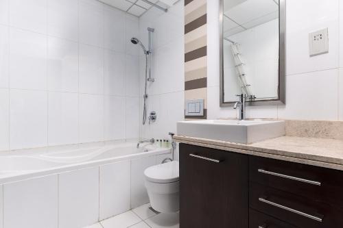 a bathroom with a sink and a toilet and a mirror at BellaVista - Spectacular - 2 BR Penthouse - Boulevard Central - Panoramic Terrace & Burj Khalifa View in Dubai