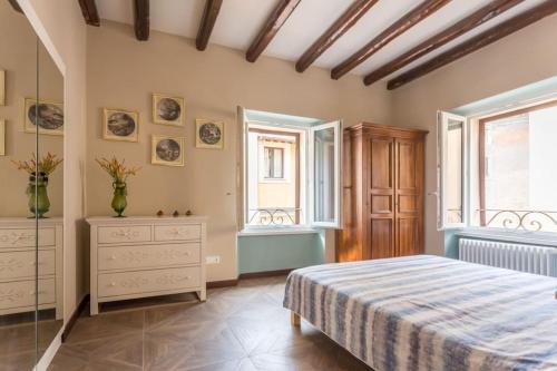 Schlafzimmer mit einem Bett, einer Kommode und Fenstern in der Unterkunft Frangipane 31 Monti Terrace in Rom