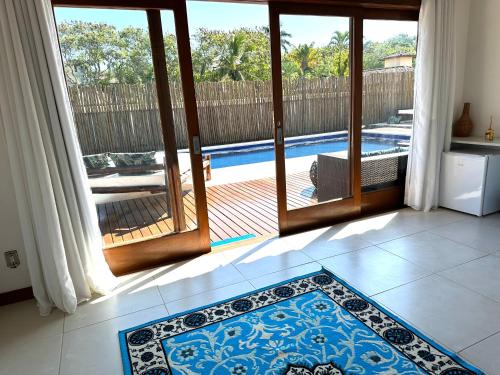 a room with a door open to a swimming pool at Villa Ferradura Mar in Búzios