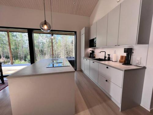 a kitchen with white cabinets and a counter top at Villa Aurinkorinne Himos in Jämsä