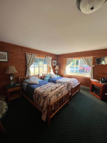 a bedroom with two beds and two windows at Deer Harbor Inn in Deer Harbor