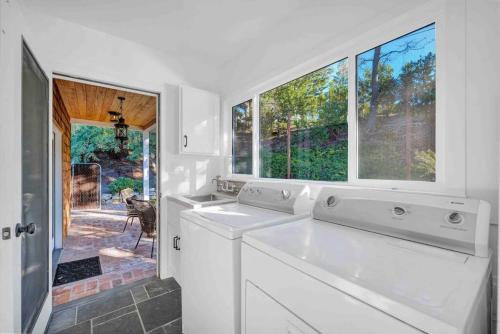 una cocina blanca con 2 lavabos y una ventana en Modern Family Farmhouse with Pool, Jacuzzi, Putting Green, Treehouse, Bocce and more, en Thousand Oaks