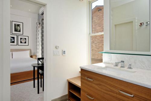 uma casa de banho com um lavatório e um quarto com uma cama em Independence Square 212, Studio with Beautiful Finishes. A+ Location in Downtown Aspen em Aspen