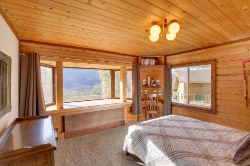 um quarto com uma cama e janelas num camarote em Log Cabin Rental in Eagle River Pets Welcome! em Eagle River