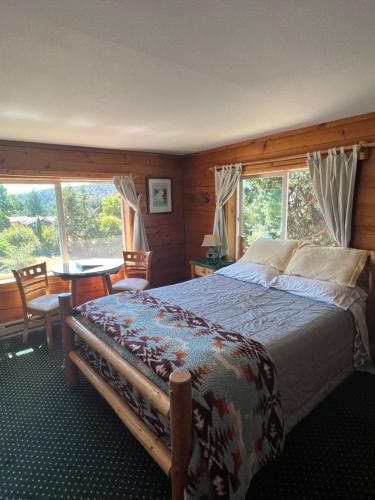 a bedroom with a bed and a table and windows at Deer Harbor Inn in Deer Harbor