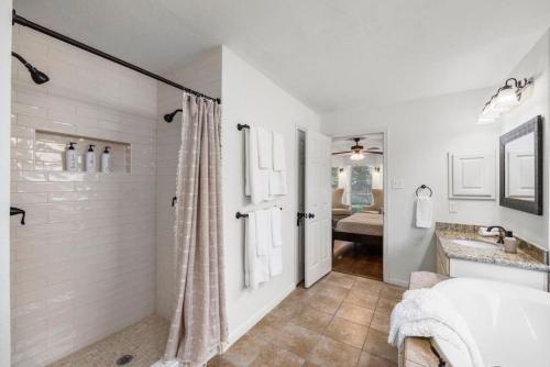 a white bathroom with a shower and a sink at 5BR Train Theme Heated Pool Hot Tub EV BBQ in Spring