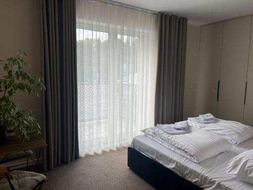 a bedroom with a bed and a large window at Apartament 4 Park City in Ostrów Wielkopolski