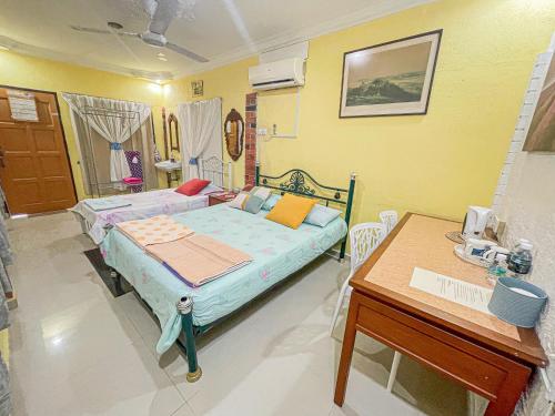 Habitación hospitalaria con cama y escritorio en Dusun Indah Cottage 1, en Bayan Lepas