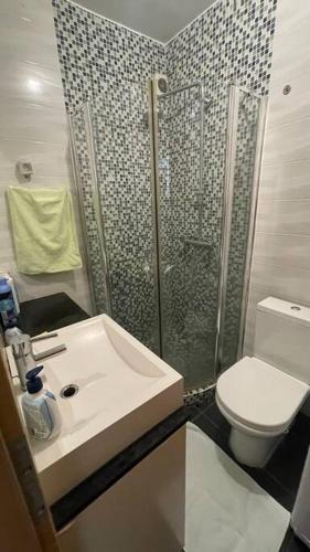 uma casa de banho com um chuveiro, um lavatório e um WC. em Skopje Centre apartment em Skopje