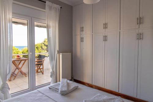 een slaapkamer met witte kasten en uitzicht op een patio bij Chios BnB in Chios