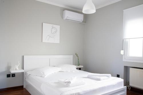 een witte slaapkamer met een bed met witte lakens bij Chios BnB in Chios