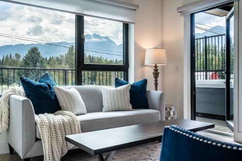 a living room with a couch and a large window at Stoked 4Ever - Revelstoke Condo (+Hot Tub) in Revelstoke