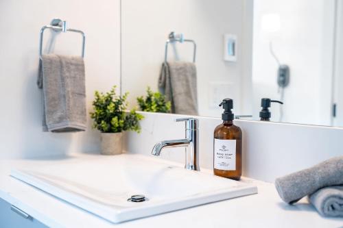 a bathroom sink with a bottle of soap on it at Stoked 4Ever - Revelstoke Condo (+Hot Tub) in Revelstoke