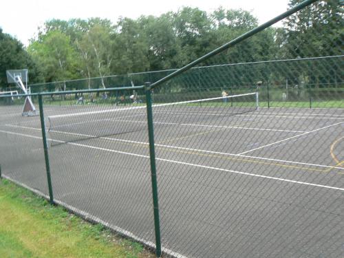 a tennis court with two people playing tennis at Hotel De Watermolen in Bocholt