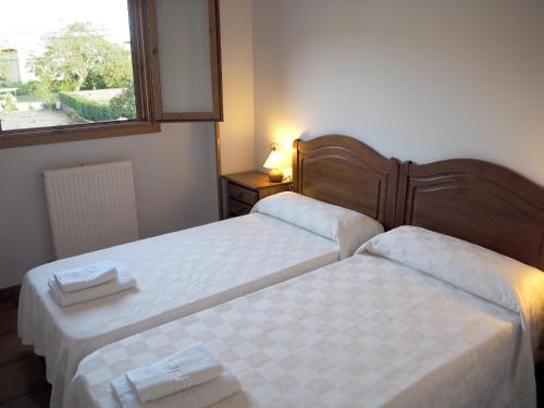 two beds in a small room with a window at Posada de Ollo in Ollo