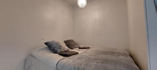Bett in einem weißen Zimmer mit zwei Kissen darauf in der Unterkunft City Home Taimi in Rovaniemi