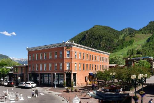 a large brick building in front of a mountain at Independence Square 304, Stylish Hotel Room with Downtown Views & Great Location in Aspen
