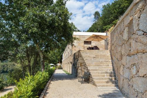 a stone wall with stairs next to a building at Douro Green in Castelo de Paiva