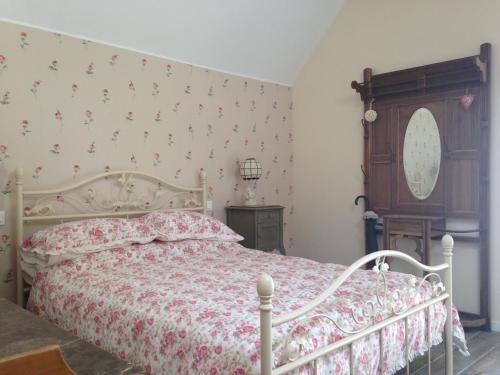 a bedroom with a bed with a floral bedspread at L'Auberge Des Oiseaux Chantants in Willeman
