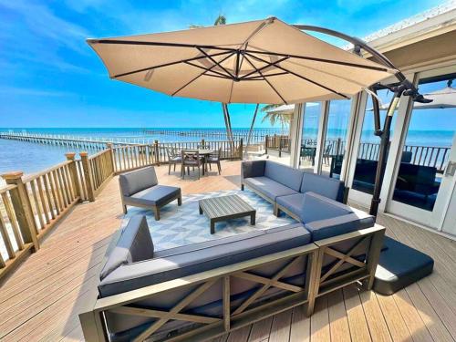 a patio with a couch and an umbrella and a table at Bungalows Sugarloaf Beach Key West - Hammock House in Sugarloaf Shores
