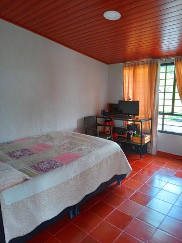 a bedroom with a bed and a television in it at Casa Campo La Milagrosa in Cómbita