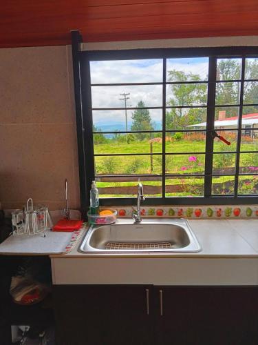 a kitchen sink and a window with a view of a field at Casa Campo La Milagrosa in Cómbita