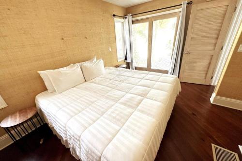 a large white bed in a room with a window at Bungalows Sugarloaf Beach Key West - Hammock House in Sugarloaf Shores